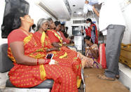 In this Friday, Dec. 14, 2018 photo, Indians are brought in an ambulance for treatment after a case of suspected food poisoning, at a hospital in Mysore, Karnataka state, India. Police on Saturday arrested three people after at least 10 died of suspected food poisoning following a ceremony to celebrate the construction of a new Hindu temple in southern India. (AP Photo/Madhusudhan Sr)