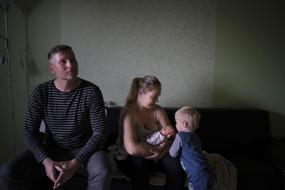 In this Nov. 11, 2018, photo, Renata Kupcova Kazimirova holds her daughter Sona next to her son Vladko, right, as she sits with her husband Vladimir in their home in Hlohovec, Slovakia. Kazimirova had her daughter Sona in early November, and was told they were both healthy. But when she informed the head of obstetrics that she wanted to leave with her baby the following day, a struggle ensued. (AP Photo/Felipe Dana)