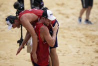 Anders Bernsten Mol, top, of Norway, is carried by his teammate Christian Sandle Sorum after winning a men's beach volleyball quarterfinal match against the Russian Olympic Committee at the 2020 Summer Olympics, Wednesday, Aug. 4, 2021, in Tokyo, Japan. (AP Photo/Petros Giannakouris)