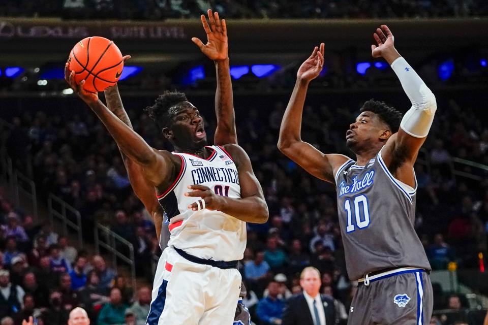 Connecticut's Adama Sanogo passes the ball away from Seton Hall's Alexis Yetna during the first half of an NCAA college basketball game at the Big East conference tournament Thursday, March 10, 2022, in New York. (AP Photo/Frank Franklin II)