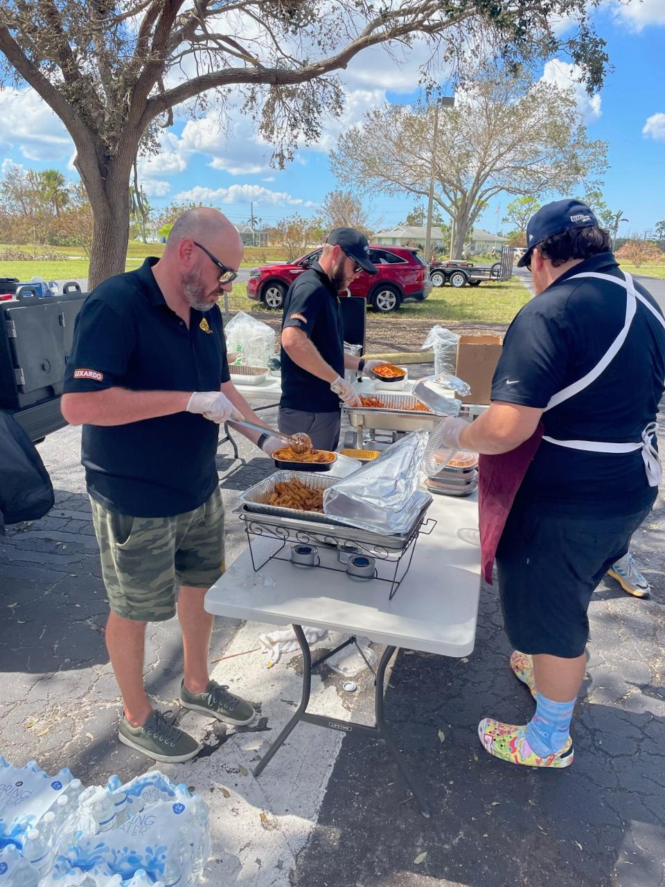 Jupiter chef/restaurateur David Schroeder (left) portions out pasta dishes for Hurricane Ian survivors in Cape Coral.