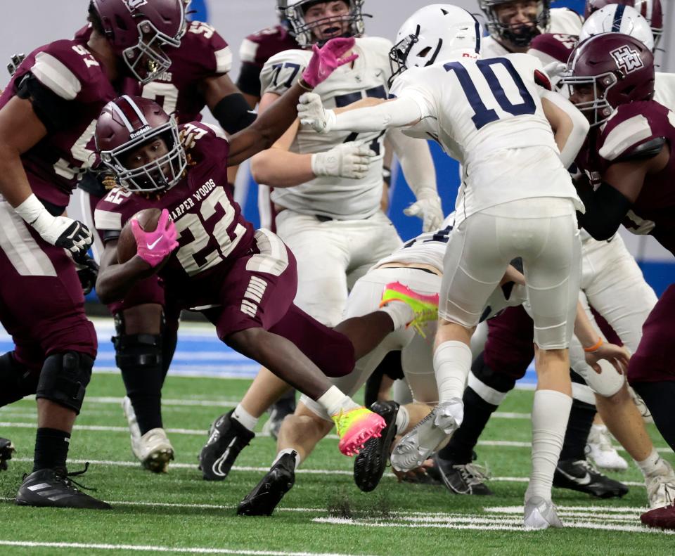 Harper Woods' Donald Adams forces his way through the Grand Rapids South Christian defense during Harper Woods' 33-27 win in the Division 4 football state title game on Saturday, Nov. 25, 2023, at Ford Field.