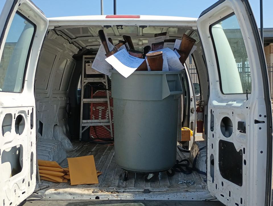 A trash can full of rifles bought back from Stockton residents during a gun buyback program on Saturday, September 16, 2023. Handguns were stored in the manila envelopes to the left.