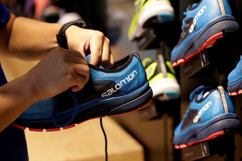 FILE PHOTO: A shop assistant holds a shoe at a Salomon store in Beijing