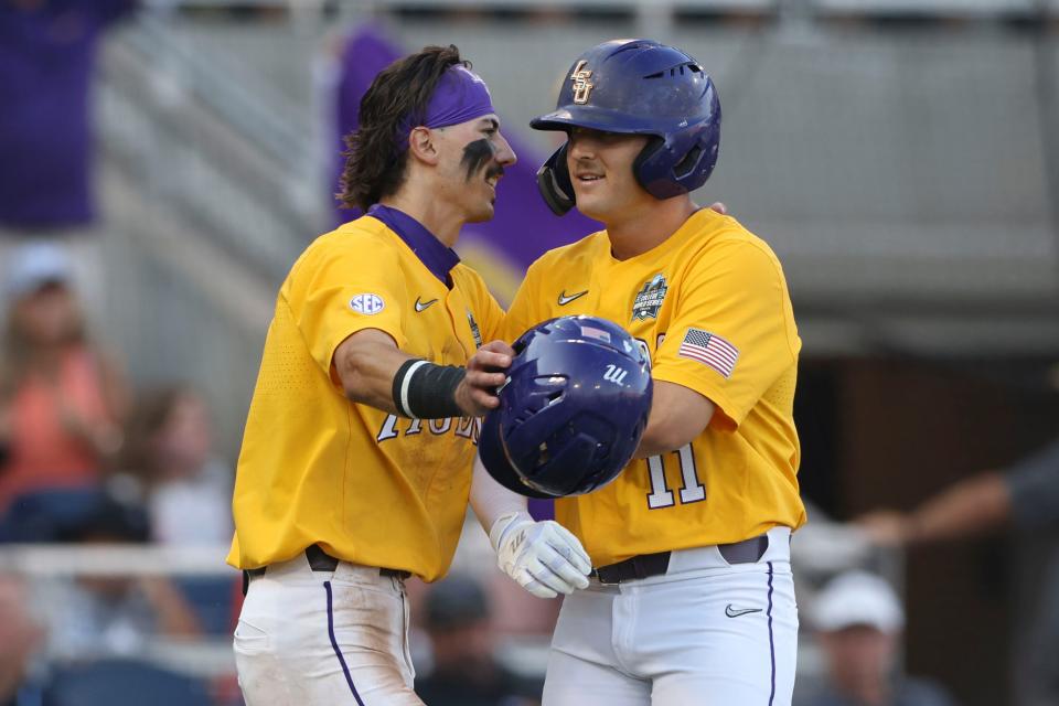 LSU's Josh Pearson (11) celebrates at the plate with Jordan Thompson after hitting a two-run homer in the fourth inning of Game 3 of the NCAA College World Series final.