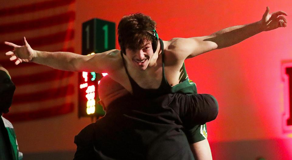 Nordonia's Salvatore Perrine leaps into the arms of his coach Jason Walters after winning the 182 pound championship match in the Division I OHSAA State Wrestling Tournament at Hilliard Darby High School, Sunday, March 14, 2021, in Hilliard, Ohio. [Jeff Lange/Beacon Journal]
