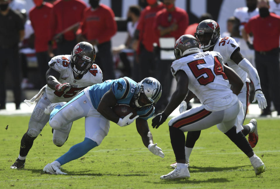 Carolina Panthers running back Mike Davis (28) splits between Tampa Bay Buccaneers linebacker Devin White (45) and outside linebacker Lavonte David (54) during the second half of an NFL football game Sunday, Sept. 20, 2020, in Tampa, Fla. (AP Photo/Jason Behnken)