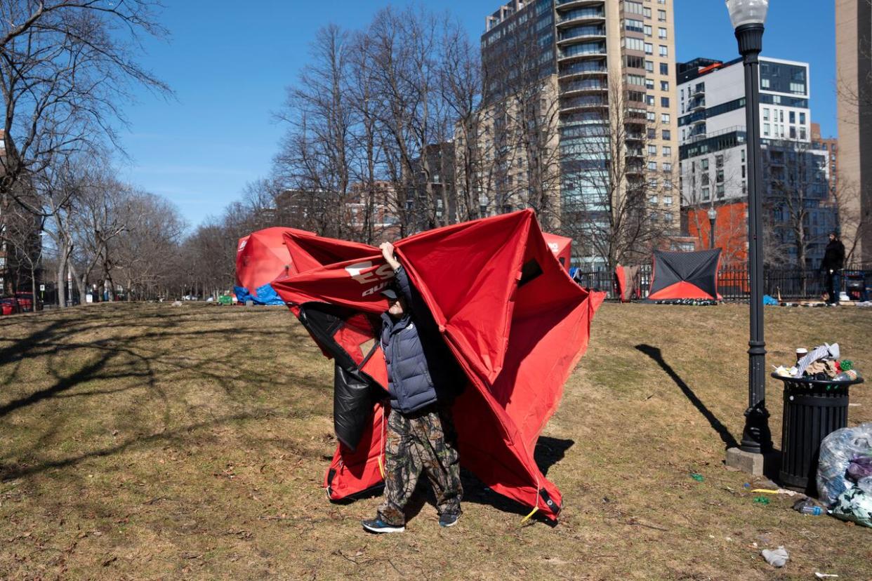 A person relocates their tent from the homeless encampment in Victoria Park in downtown Halifax on Monday, March 4, 2024. A fence was erected around the perimeter of the park as officials began working with the few remaining residents to leave the de-designated encampment site. ( THE CANADIAN PRESS/Darren Calabrese - image credit)
