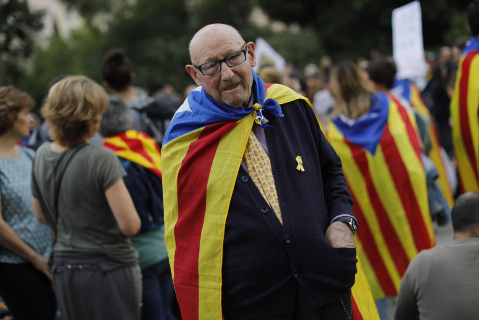 An elderly man joins a pro-independence gathering outside the Sagrada Família basilica i on the fifth day of protests over the conviction of a dozen Catalan independence leaders in Barcelona, Spain, Friday, Oct. 18, 2019. Various flights into and out of the region are cancelled Friday due to a general strike called by pro-independence unions and five marches of tens of thousands from inland towns are expected converge in Barcelona's center on Friday afternoon for a mass protest with students to and workers who are on strike. (AP Photo/Bernat Armangue)