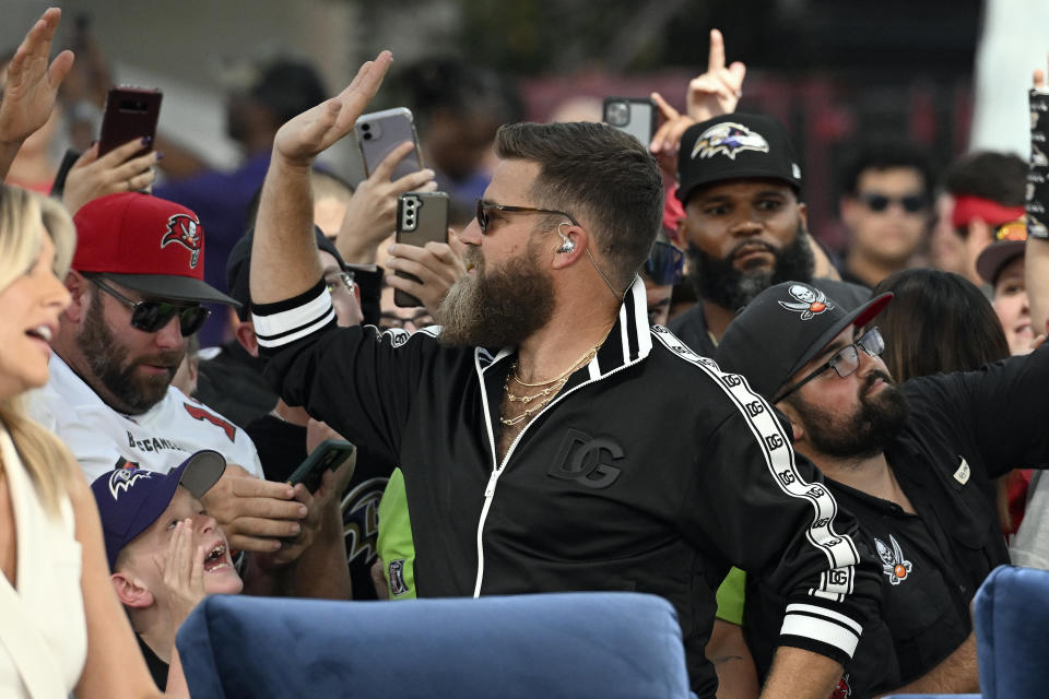 Thursday Night Football analyst Ryan Fitzpatrick high fives fans during a break before an NFL football game between the Baltimore Ravens and Tampa Bay Buccaneers Thursday, Oct. 27, 2022, in Tampa, Fla. (AP Photo/Jason Behnken)