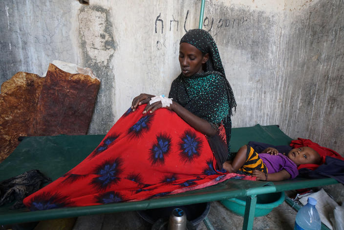 <p>Inside an abandoned prison turned Cholera Treatment Center (CTC), a young cholera victim with her child await medical treatment. With clean water now and expensive to buy, many have had to resort to drinking from unsafe water supplies thereby increasing the risks to disease and, in particular, cholera. (Photo: Giles Clarke/Getty Images) </p>