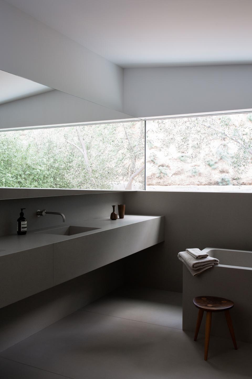 All of the bathrooms were inspired by those in architect John Pawson’s Baron House. They feature concrete tubs and vanities, all in a muted gray concrete. The faucet is from d line and the towels are from Waterworks.