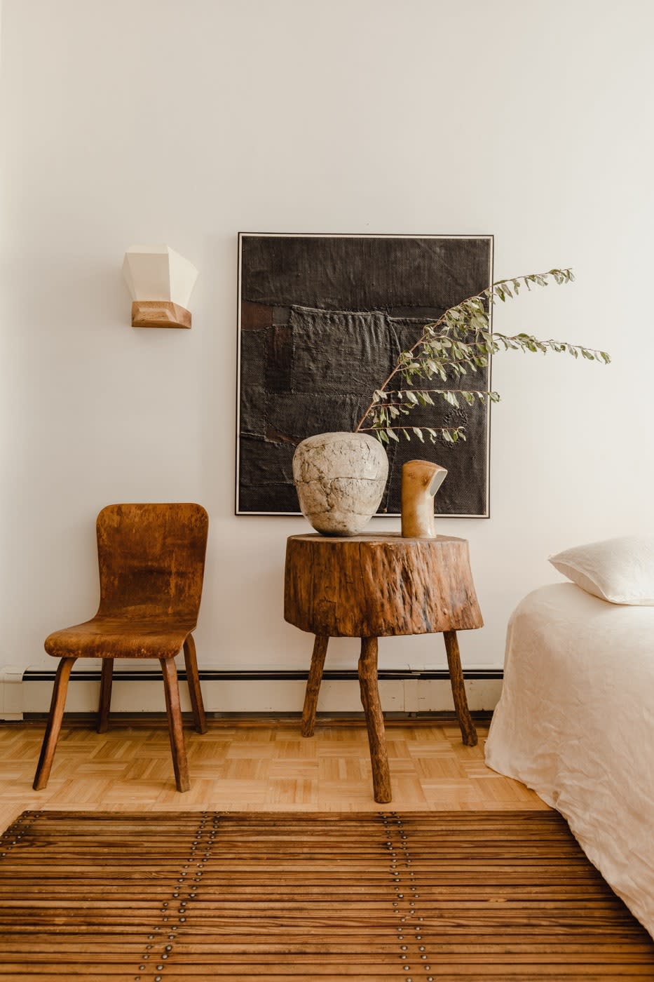 Next to a bent-plywood chair from the 1950s, a primitive butcher block from Paula Rubenstein holds a 1950s vase and a 1960s light by Pierre Lèbe Virebent circa 1960.