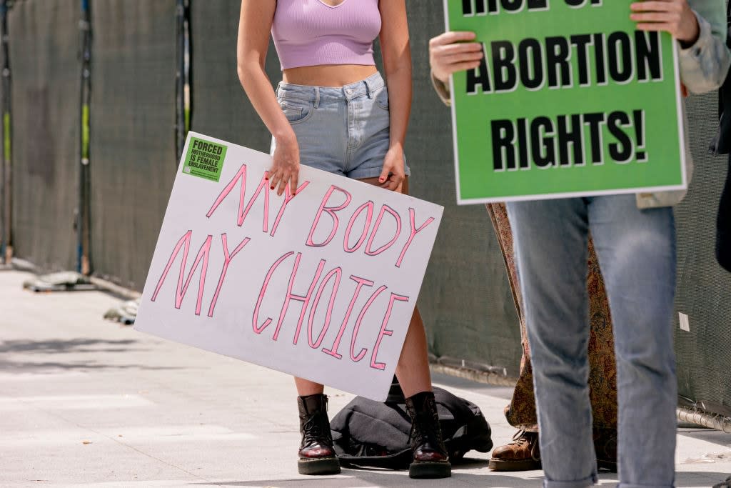 Protestors hold pro-choice signs outside of the federal courthouse following the overturning of Roe v. Wade, before marching to City Hall on Wednesday, July 6, 2022 in downtown Los Angeles, CA. (Wesley Lapointe / Los Angeles Times via Getty Images)