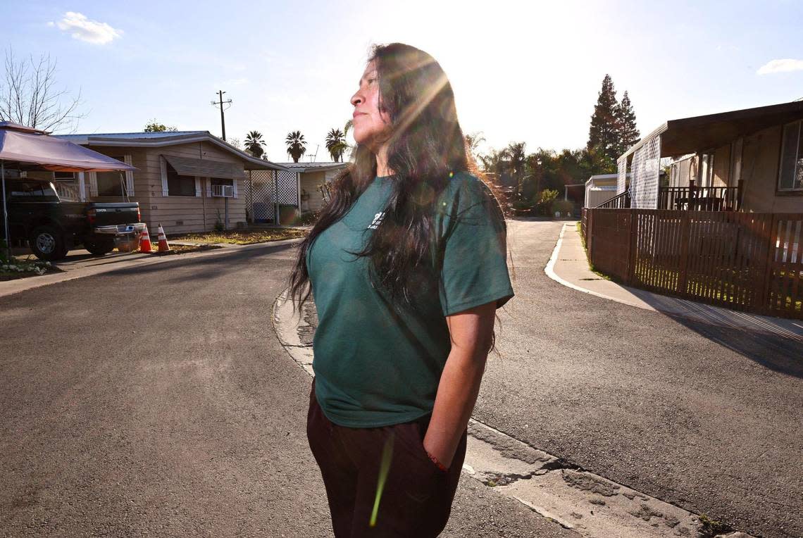 Xochilt Nuñez, who immigrated from Mexico in 1999, stands in the street at her mobile home park in Orosi, a small community in Tulare County, on Tuesday, March 26. Nunez has spent years advocating for farmworker and immigrant rights and yet describes frustration and anger with the recent waves of migrants.