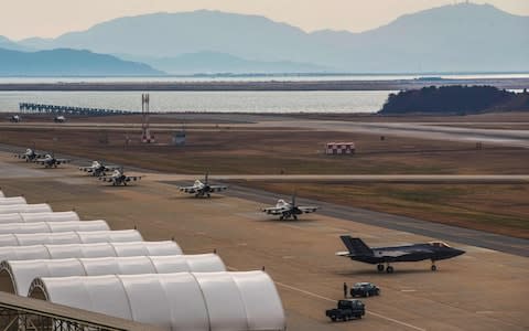 US Air Force F-16 Fighting Falcon and F-35A Lightning II (R) fighter jets taxiing at Kunsan Air Base in the southwestern port city of Gunsan  - Credit:  AFP