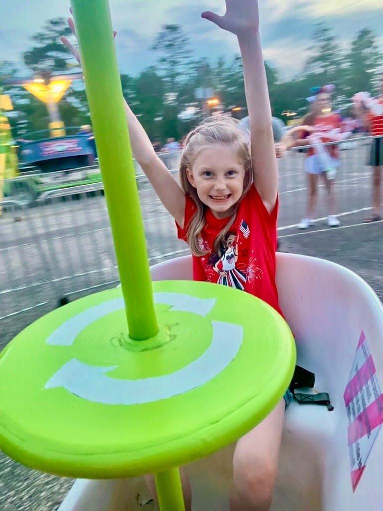 Haley Foster, 8, spins on one of the carnival rides at the annual Independence Day celebration in Chatom, Alabama, on July 3, 2023.