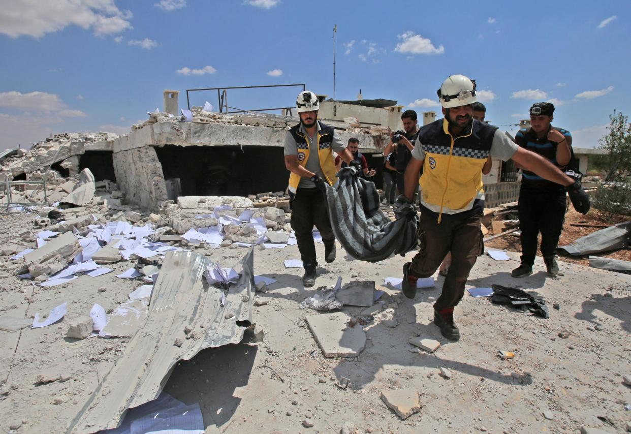 Members of the White Helmets carry away in a blanket the body of a victim following a reported airstrike: AFP/Getty