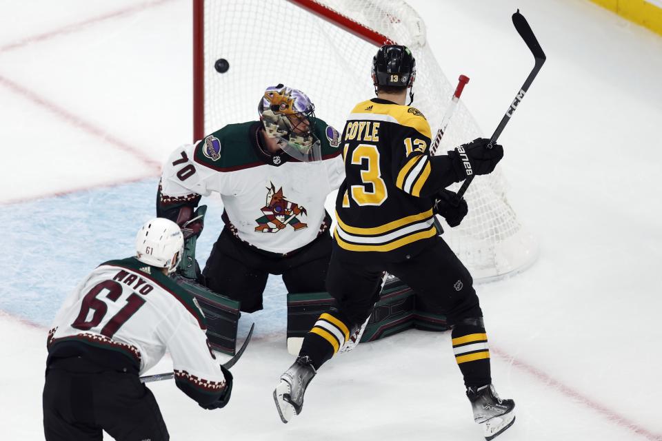 Boston Bruins' Charlie Coyle (13) scores against Arizona Coyotes' Karel Vejmelka (70) during the first period of an NHL hockey game, Saturday, Oct. 15, 2022, in Boston. (AP Photo/Michael Dwyer)