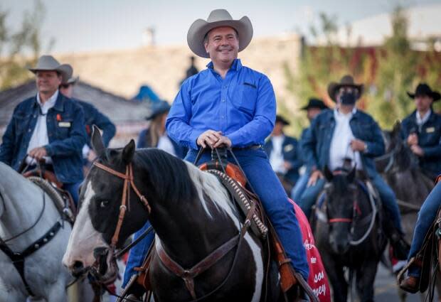 Alberta Premier Jason Kenney rides in the Calgary Stampede parade on July 9. At least 129 people caught COVID at the 10-day festival.  (Jeff McIntosh/Canadian Press - image credit)