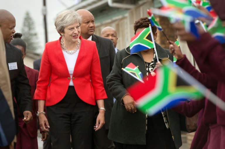 Britain's Prime Minister Theresa May is greeted by schoolchildren waving British and South African flags during a visit to the ID Mkhize Secondary School in Gugulethu township, about 15 km from the centre of Cape Town, on August 28, 2018