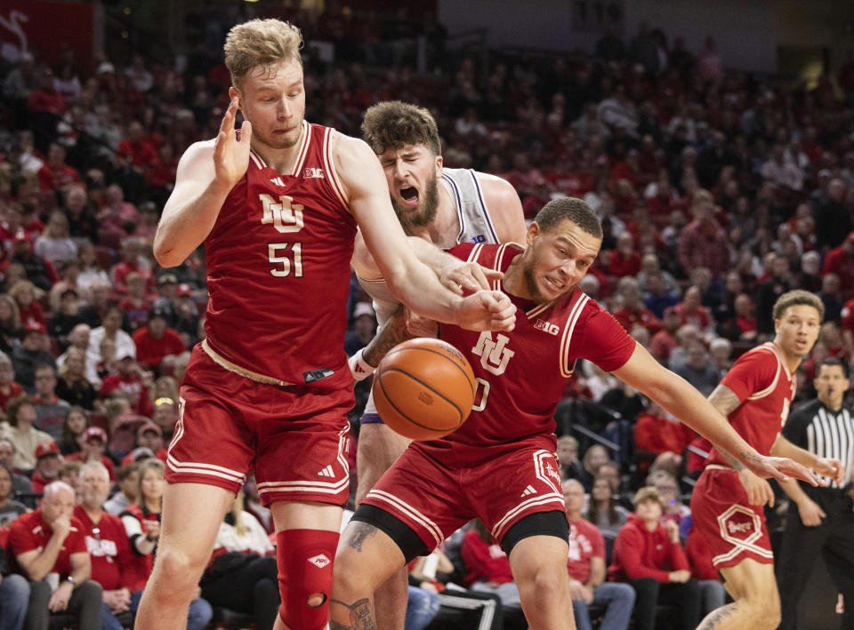 Northwestern's Matthew Nicholson, center, reaches for a rebound between Nebraska's Rienk Mast, left, and C.J. Wilcher during the second half of an NCAA college basketball game Saturday, Jan. 20, 2024, in Lincoln, Neb. Nebraska defeated Northwestern 75-69. (AP Photo/Rebecca S. Gratz)