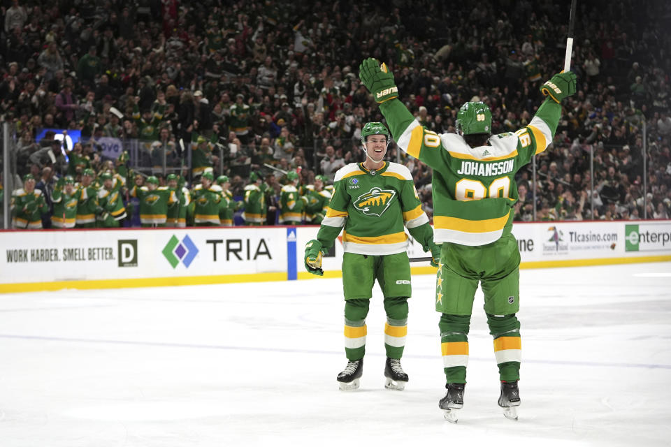 Minnesota Wild defenseman Declan Chisholm, left, celebrates with left wing Marcus Johansson (90) after scoring during the third period of an NHL hockey game against the Buffalo Sabres, Saturday, Feb. 17, 2024, in St. Paul, Minn. (AP Photo/Abbie Parr)