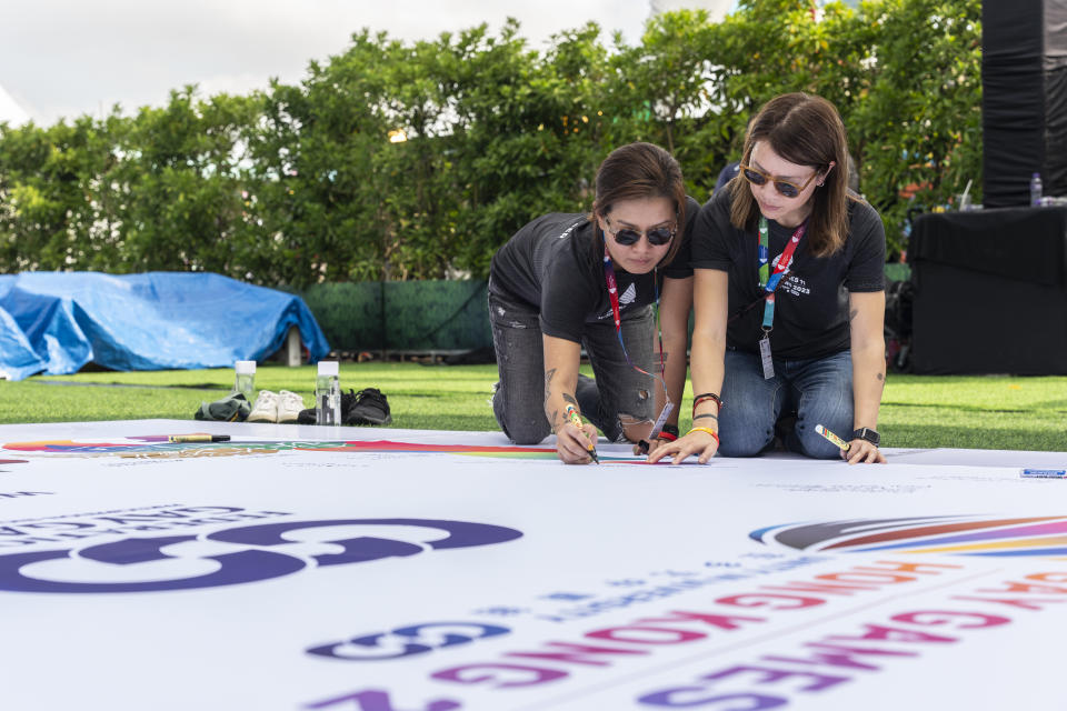 Participants sign on the quilt at the AIDS Quilt Memorial Ceremony, ahead of the Gay Games in Hong Kong, Saturday, Nov. 4, 2023. The first Gay Games in Asia are fostering hopes for wider LGBTQ+ inclusion in the regional financial hub, following recent court wins in favor of equality for same-sex couples and transgender people. (AP Photo/Chan Long Hei)