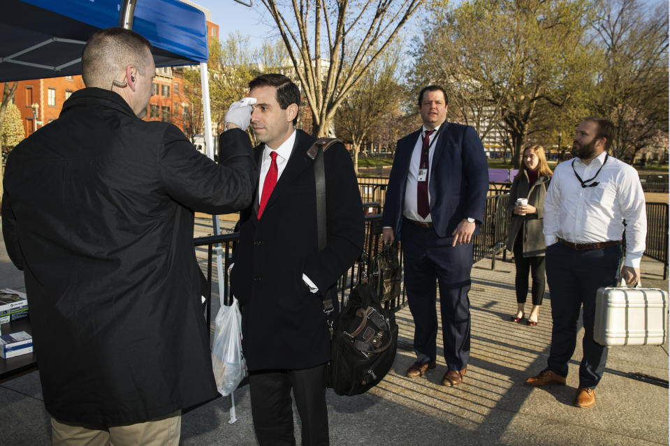 Journalists and White House staff's body temperature are checked by White House medical staff before they enter the White House perimeter, Monday, March 16, 2020, in Washington. (AP Photo/Manuel Balce Ceneta)