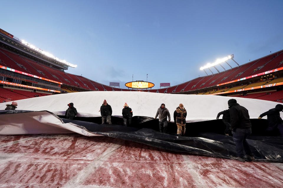 Grounds crew workers pull on a tarp at Arrowhead Stadium before an NFL wild-card playoff football game between the Kansas City Chiefs and the Miami Dolphins, Saturday, Jan. 13, 2024 in Kansas City, Mo. (AP Photo/Ed Zurga)
