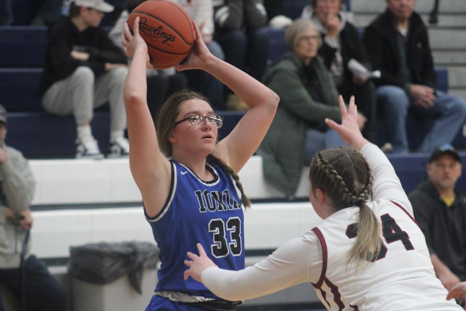 Ionia senior guard Rajalyaj Esquivel (No. 33) looks to pass while Portland sophomore guard Paige Spedoske defends during a MHSAA Division 2 district championship game Friday, March 3, at Lakewood High School. Portland won the game, 45-26, to win its fourth consecutive district title.