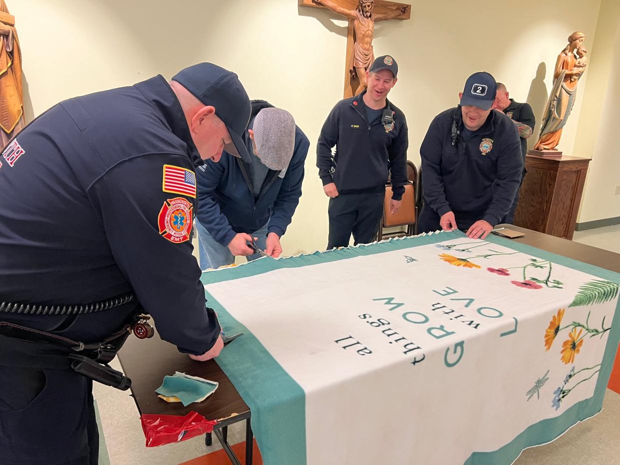 Weymouth firefighters assemble one of the fleece blankets that will be given to a first responder struggling with mental illness.