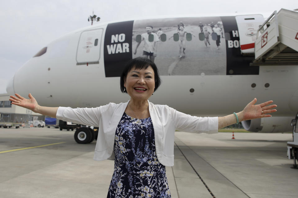 Kim Phuc, the girl in the famous 1972 Vietnam napalm attack photo, poses for a picture in front of a plane transporting refugees fleeing the war in Ukraine to Canada, from Frederic Chopin Airport in Warsaw, Poland, Monday, July 4, 2022. Phuc's iconic Associated Press photo in which she runs with her napalm-scalded body exposed, was etched on the private NGO plane that flew the refugees Monday to the city of Regina, the capital of the Canadian province of Saskatchewan. (AP Photo/Michal Dyjuk)