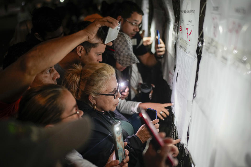 Los votantes consultan las listas electorales antes de la apertura de las urnas para las elecciones presidenciales en Caracas, Venezuela, el domingo 28 de julio de 2024 (AP Foto/Matías Delacroix)