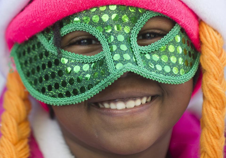 A spectator smiles as she watches the annual St. Patrick's Day parade in Montreal, Sunday, March 16, 2014. (AP Photo/The Canadian Press, Graham Hughes)