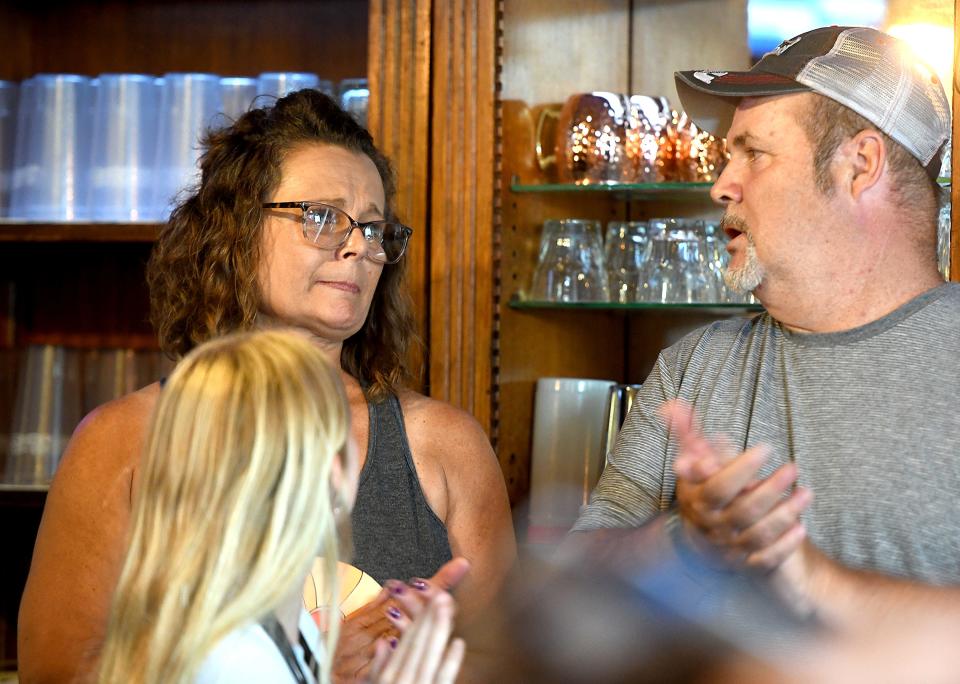 Rae and Tom Fry, the last owners of The Normandy Inn in Minerva, stand close by as their established turnkey business is sold at auction.