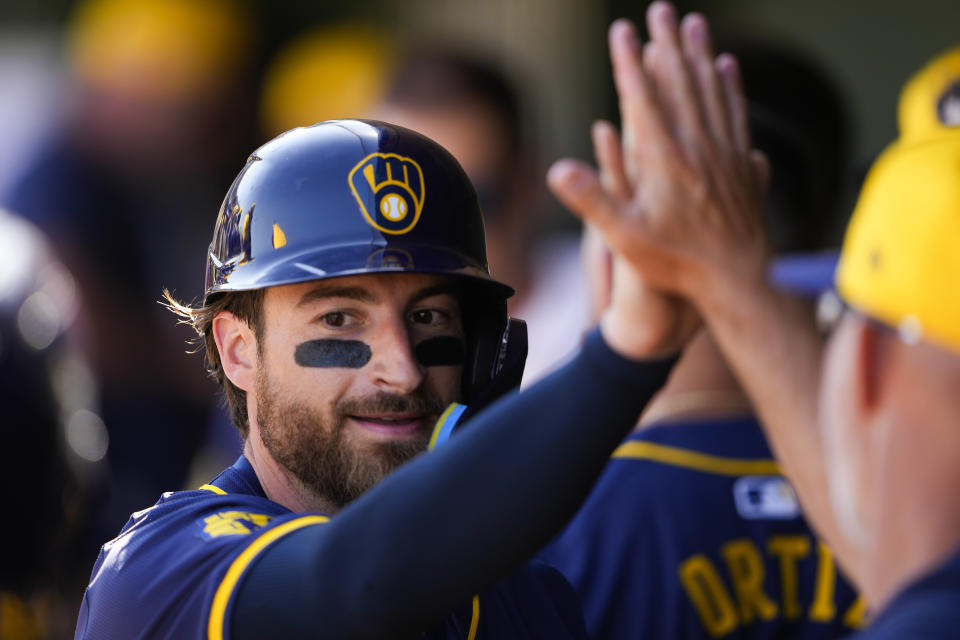 Milwaukee Brewers' Eric Haase is greeted in the dugout after scoring on an RBI double by Brock Wilken against the Texas Rangers during the third inning of a spring training baseball game Thursday, Feb. 29, 2024, in Surprise, Ariz. (AP Photo/Lindsey Wasson)