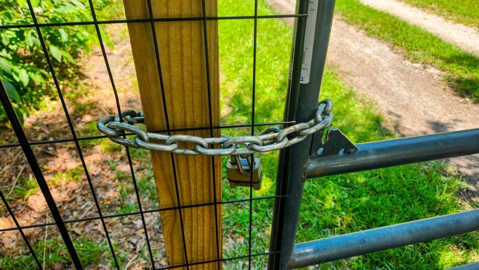 The locked gate at Terri Aigner’s property and neighbors as photographed on Wednesday, July 10, 2024 at the end of Everest Road on St. Helena Island. Aigner, who maintains that the road is private, placed the gate after numerous vehicles and large trucks used by funeral homes, damaged the road after a heavy rainfall, leaving it impassable.