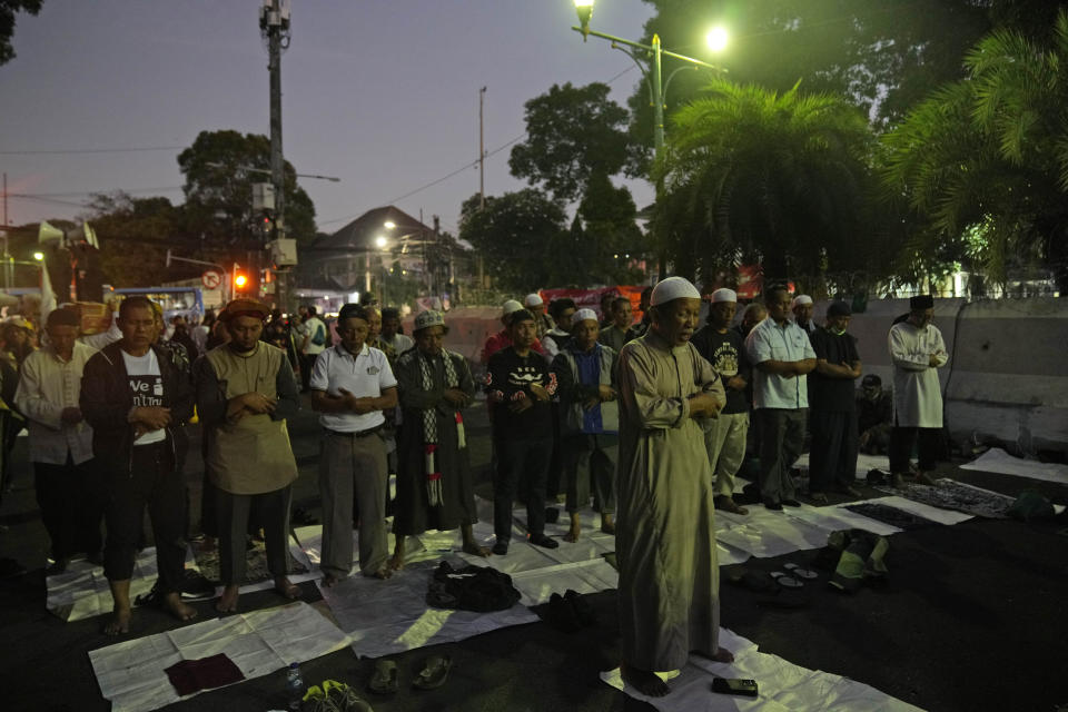 Protesters pray during a rally alleging a widespread fraud in the Feb. 14 presidential election, ahead of the announcement of the election results, outside the General Election Commission's office in Jakarta, Indonesia, Wednesday, March 20, 2024. Presidential frontrunner Prabowo Subianto, a former general linked to past human rights abuses and his running mate Gibran Rakabuming Raka, the eldest son of Indonesian President Joko Widodo, are currently leading the tally with nearly 60% of the votes. (AP Photo/Dita Alangkara)