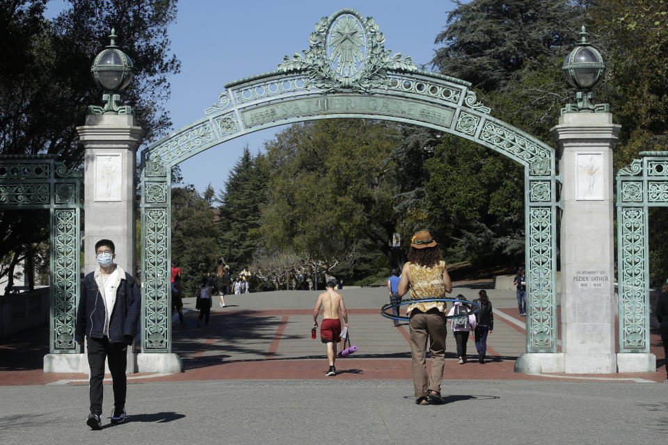 A man wears a mask while walking past Sather Gate on the University of California, Berkeley, campus on March 11, 2020. (Photo: ASSOCIATED PRESS)