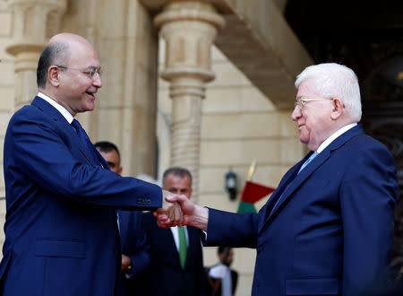 Iraq's outgoing President Fuad Masum (R) and newly elected Barham Salih, shake hands at the end of a handover ceremony at Salam Palace in Baghdad, Iraq October 3, 2018. REUTERS/Thaier Al-Sudani