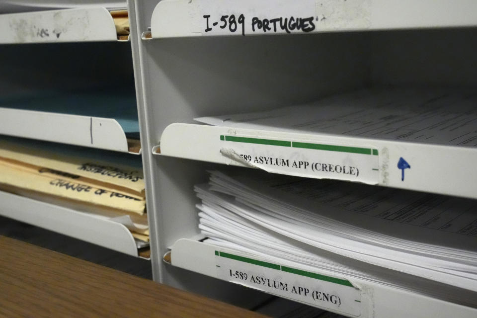 Asylum applications in different languages are shown, Wednesday, Jan. 10, 2024, in a room used by Catholic Legal Services for the Archdiocese of Miami to help asylum-seekers at an immigration court in Miami. Immigration courts are buckling under an unprecedented 3 million pending cases, most of them newly arrived asylum-seekers. The number of migrants trying to fight their deportation in front of a US judge has grown by 50% in less than a year. (AP Photo/Wilfredo Lee)