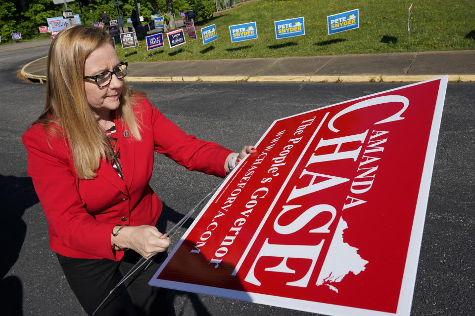 Republican gubernatorial candidate State Sen. Amanda Chase, assembles a yard sign during a drive through GOP Convention vote in Chesterfield, Va., Saturday, May 8, 2021. (AP Photo/Steve Helber)