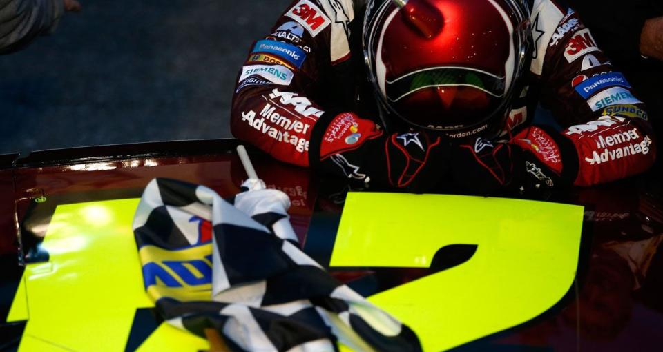 Jeff Gordon pauses for a moment with his head down and hands ont he roof of his car after his victory at Martinsville in 2015.