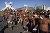 Indigenous march past the Cathedral in Brasilia, Brazil, Wednesday, June 23, 2021. Indigenous activists have traveled to the capital to demand government action to halt illegal mining and logging on their land and oppose a proposed bill they say would limit recognition of tribal lands. (AP Photo/Ricardo Mazalan)