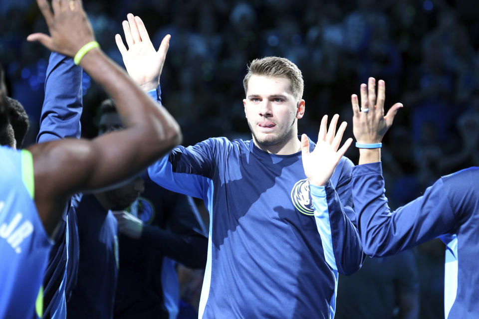 Dallas Mavericks forward Luka Doncic (77) high fives teammates after being introduced before a game against the Sacramento Kings in an NBA basketball game Sunday, Dec. 8, 2019, in Dallas. (AP Photo/Richard W. Rodriguez)