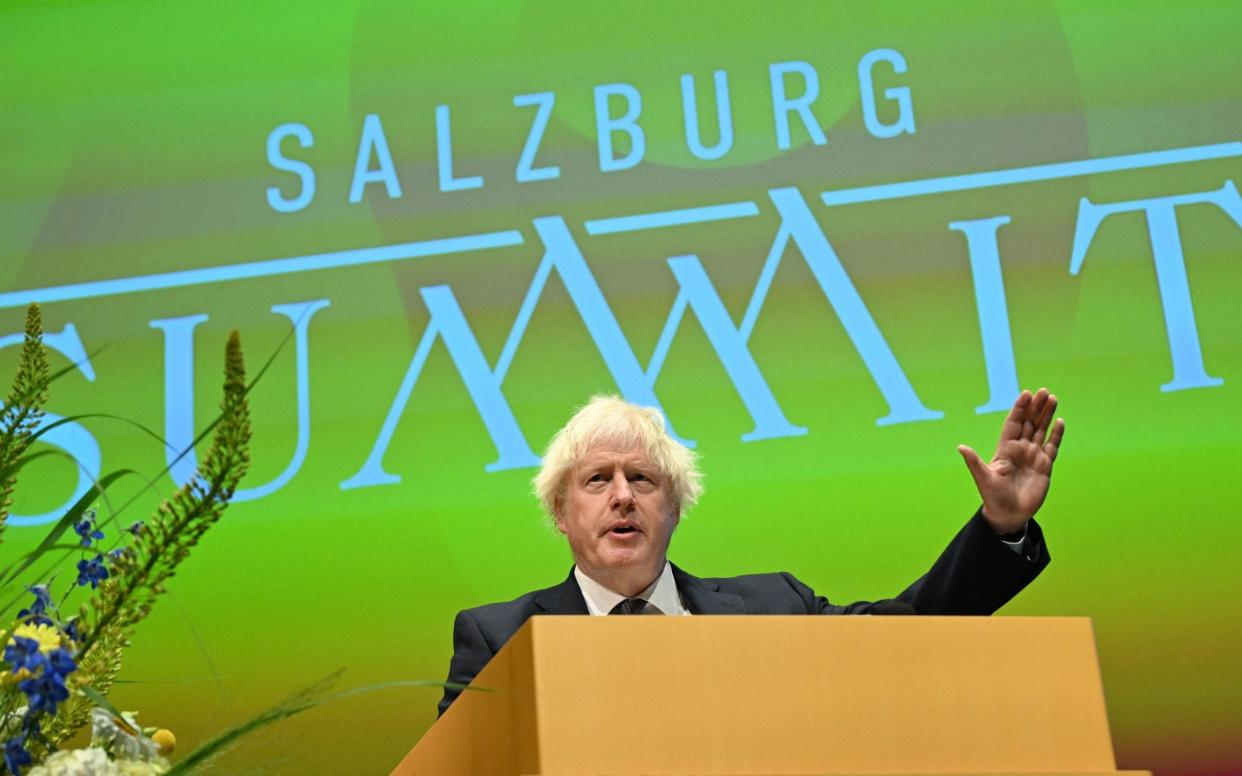 Boris Johnson gestures at a lectern