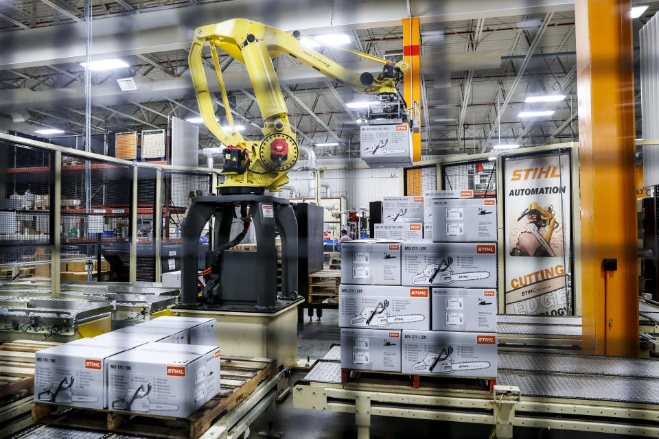 In this Thursday, May 25, 2017 photo, a giant robotic arm loads pallets full of chainsaws prepared for shipping at the Stihl Inc. production plant in Virginia Beach, Va. Despite efficiency increases and lessening the need for manual laborers, companies require workers who can program, oversee, operate, and maintain the automation. A report by Deloitte Consulting and the American Manufacturing Institute estimates 2 million such jobs will need to be filled over the next decade. (AP Photo/John Minchillo)