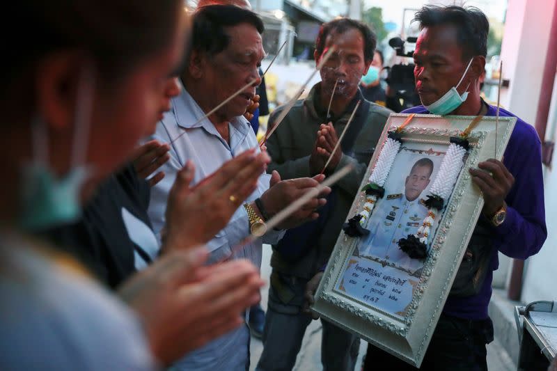 Relatives pay their respects to Captain Siriwiwat Sangprasita (seen in the portrait), a victim of a gun battle involving a Thai soldier on a shooting rampage at a hospital in Nakhon Ratchasima