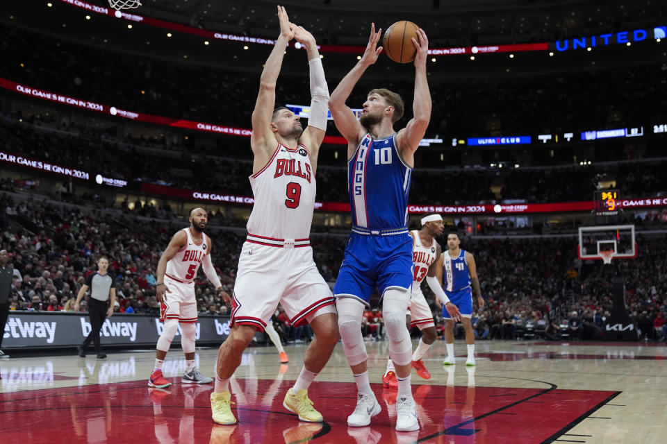 Chicago Bulls center Nikola Vucevic, left, guards Sacramento Kings forward Domantas Sabonis during the first half of an NBA basketball game Saturday, Feb. 3, 2024, in Chicago. (AP Photo/Erin Hooley)